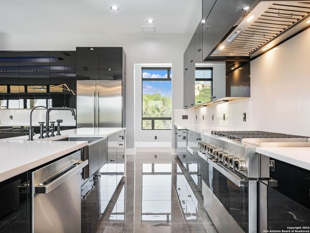 kitchen featuring premium appliances, ventilation hood, and dark tile patterned flooring