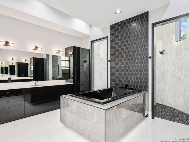 bathroom featuring vanity, independent shower and bath, and tile patterned floors