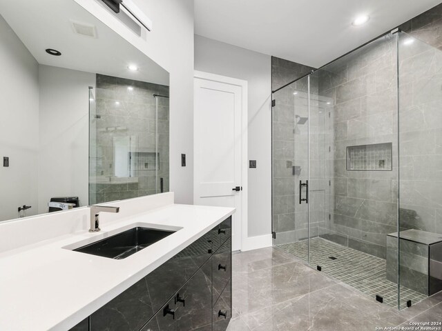 bathroom featuring tile patterned floors, vanity, and a shower with door