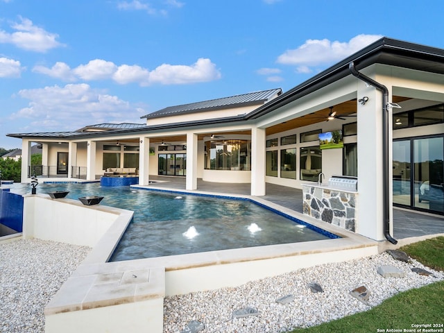 view of pool with a patio, pool water feature, and ceiling fan