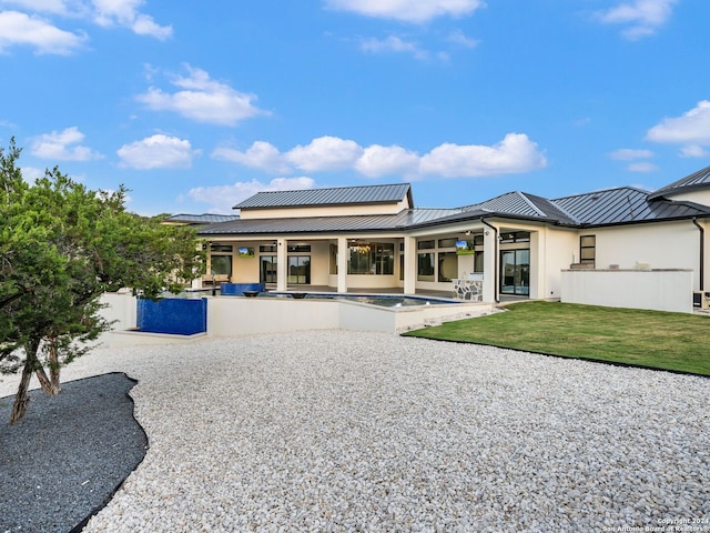 rear view of house with a patio area and a lawn