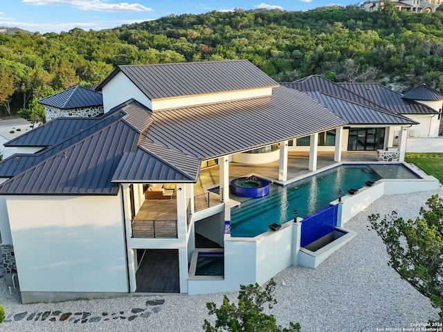 back of property featuring a balcony and a patio