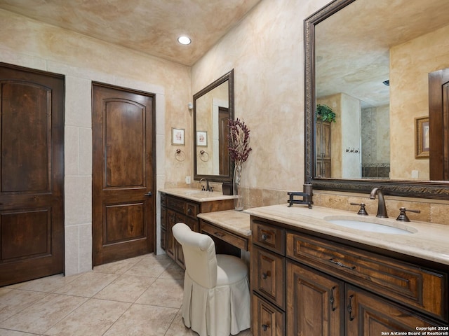 bathroom with tile floors, dual vanity, and tile walls