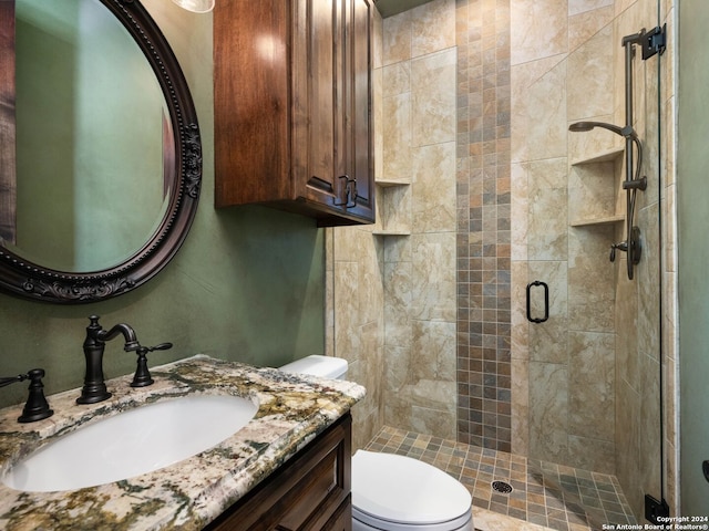 bathroom featuring vanity with extensive cabinet space, walk in shower, and toilet