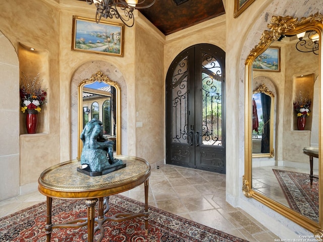 foyer with tile flooring, a high ceiling, ornamental molding, and french doors