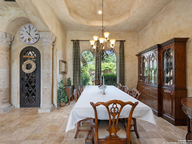 dining room with a chandelier, plenty of natural light, light tile floors, and a raised ceiling