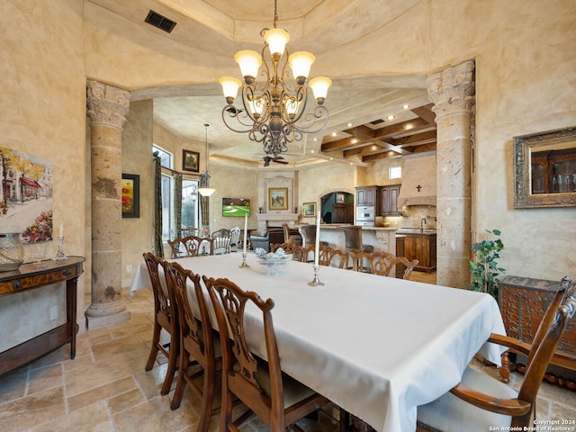 tiled dining space featuring a towering ceiling, coffered ceiling, a notable chandelier, ornate columns, and sink