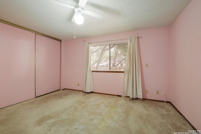 carpeted spare room with ceiling fan and a textured ceiling