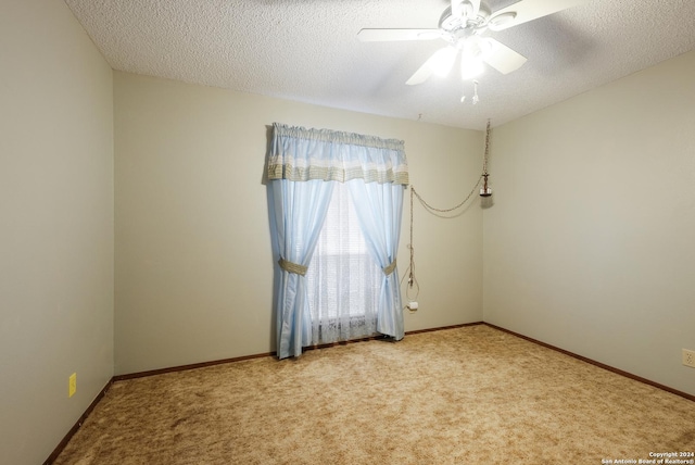 carpeted empty room featuring ceiling fan and a textured ceiling