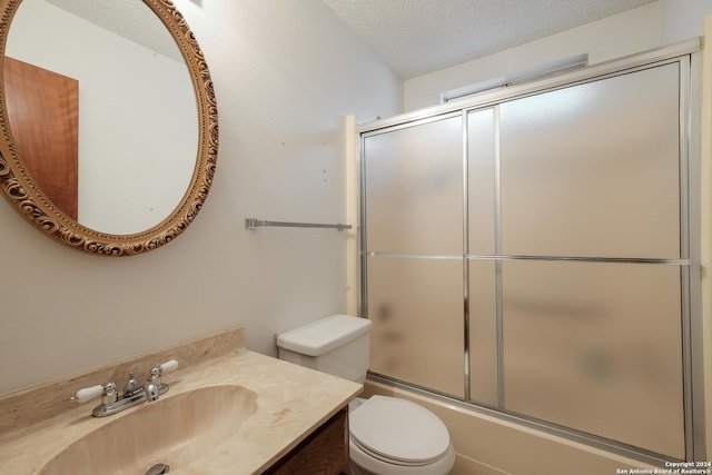 full bathroom with vanity, enclosed tub / shower combo, a textured ceiling, and toilet