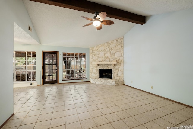 unfurnished living room featuring a stone fireplace, ceiling fan, light tile patterned flooring, and a textured ceiling