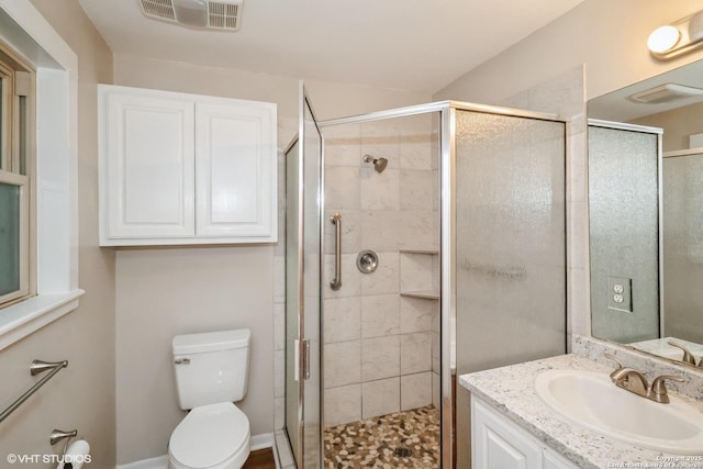 bathroom featuring vanity, toilet, and walk in shower