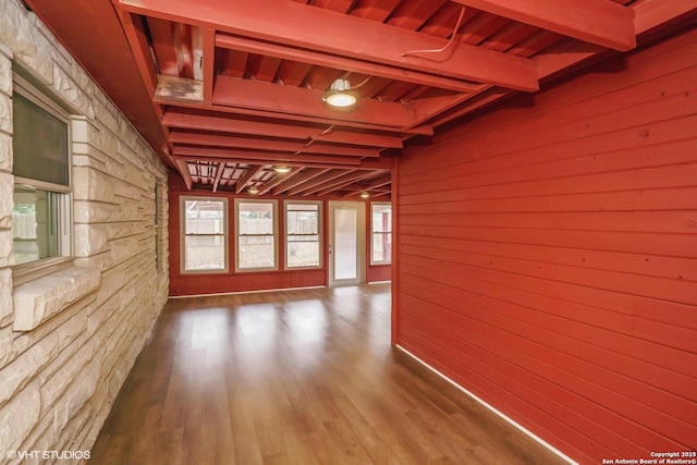 corridor featuring hardwood / wood-style flooring, wooden walls, beam ceiling, and wooden ceiling