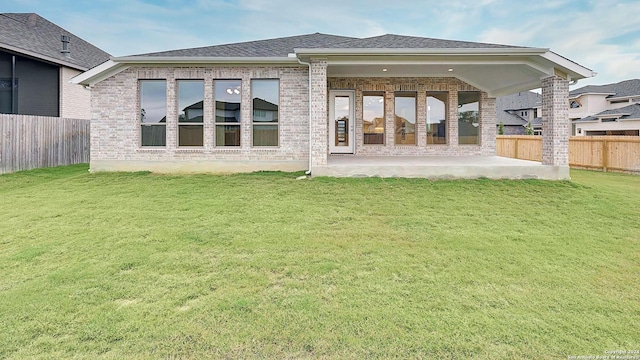 rear view of property with a lawn and a patio area