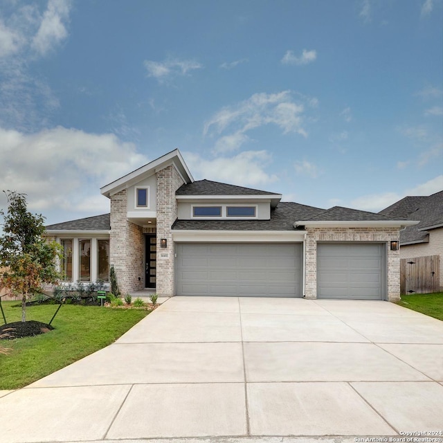 prairie-style house with a garage and a front lawn