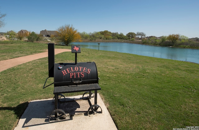 surrounding community with a yard and a water view