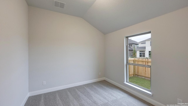 unfurnished room with carpet floors and vaulted ceiling