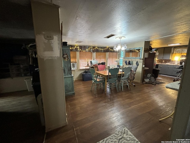 dining room with an inviting chandelier, hardwood / wood-style floors, and a textured ceiling