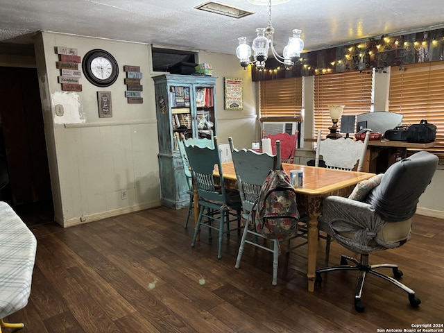 dining room featuring wood-type flooring, a textured ceiling, and an inviting chandelier