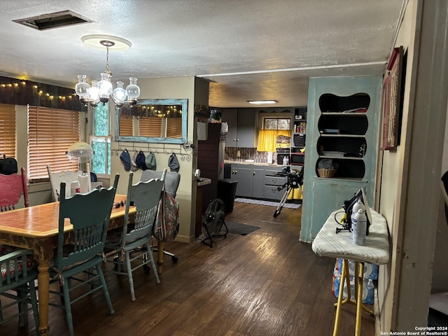 dining room featuring an inviting chandelier, dark hardwood / wood-style floors, and a textured ceiling