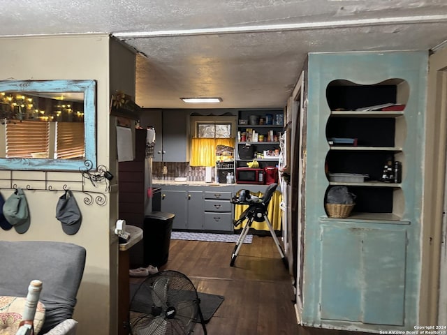 kitchen with a textured ceiling and dark hardwood / wood-style flooring