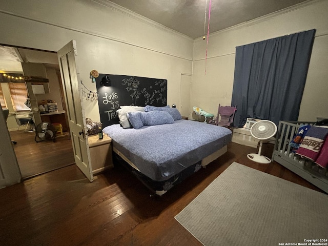 bedroom with crown molding and dark hardwood / wood-style flooring