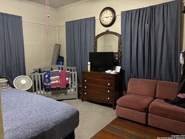 bedroom with crown molding and hardwood / wood-style flooring