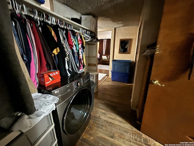 washroom featuring dark hardwood / wood-style floors, washer / dryer, and a textured ceiling