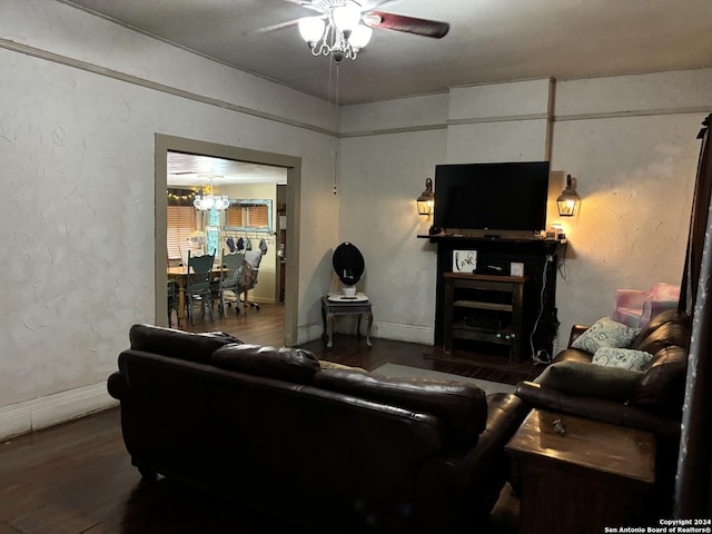 living room featuring a fireplace, hardwood / wood-style flooring, and ceiling fan with notable chandelier