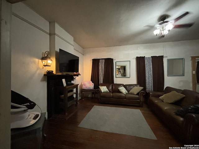 living room featuring ceiling fan and dark hardwood / wood-style floors