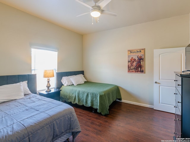 bedroom with ceiling fan and dark hardwood / wood-style flooring