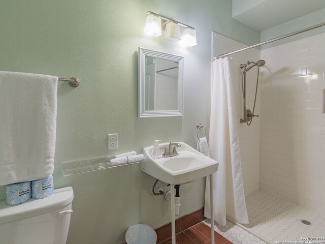 bathroom with curtained shower, sink, and toilet