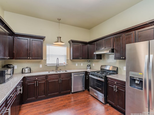 kitchen with appliances with stainless steel finishes, sink, dark hardwood / wood-style floors, and backsplash