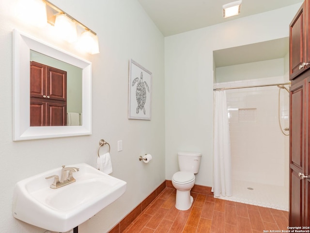 bathroom with sink, a shower with shower curtain, and toilet