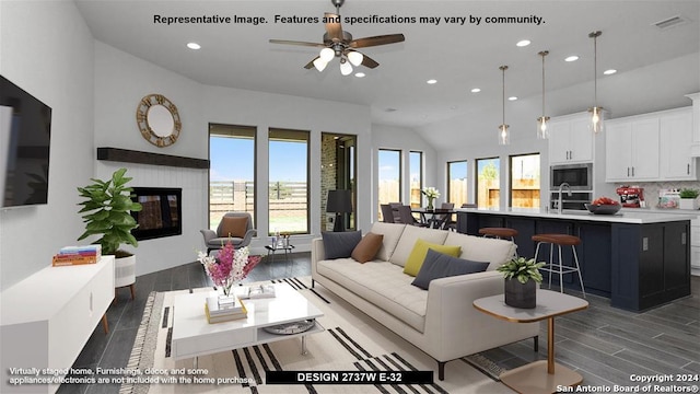 living room with lofted ceiling, dark hardwood / wood-style floors, ceiling fan, and a healthy amount of sunlight