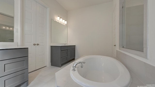 bathroom with vanity, a tub to relax in, and tile patterned floors