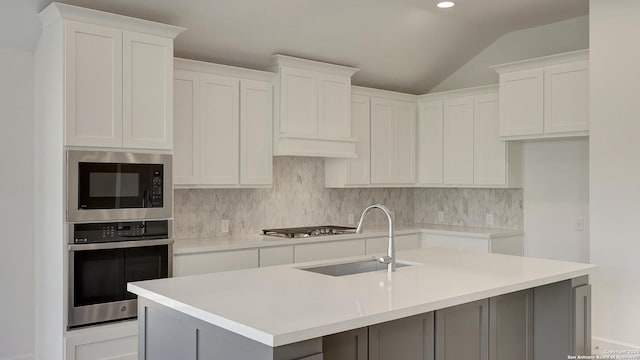 kitchen featuring a center island with sink, white cabinetry, and stainless steel appliances