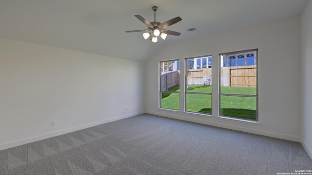 spare room featuring ceiling fan, carpet floors, and vaulted ceiling