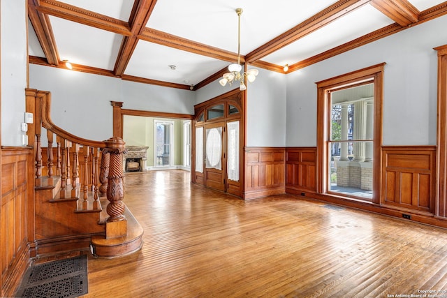 entryway featuring hardwood / wood-style flooring, a notable chandelier, coffered ceiling, and beamed ceiling