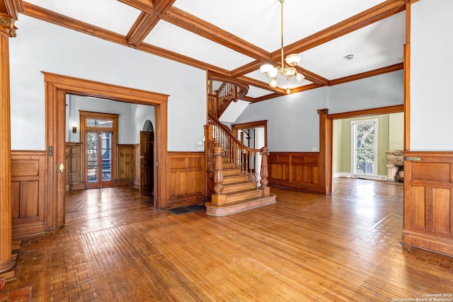 entryway with stairs, wainscoting, plenty of natural light, and coffered ceiling