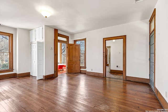 interior space featuring visible vents, dark wood finished floors, and baseboards