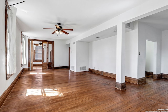 unfurnished room featuring a ceiling fan, wood-type flooring, visible vents, and baseboards