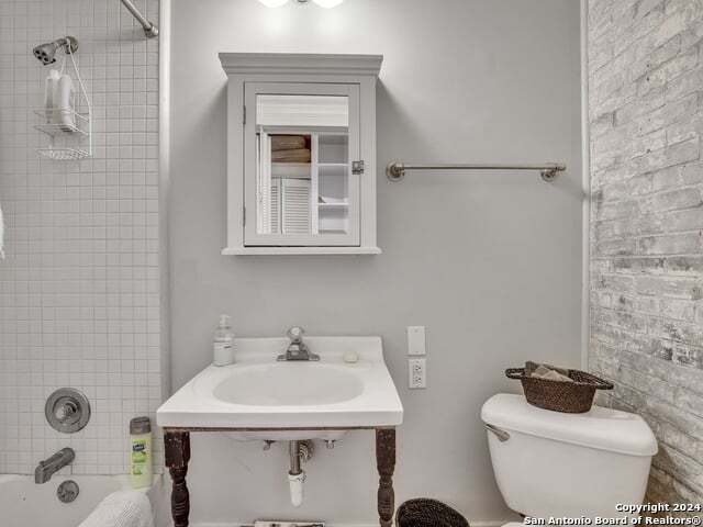 full bathroom with shower / bathing tub combination, a sink, and toilet