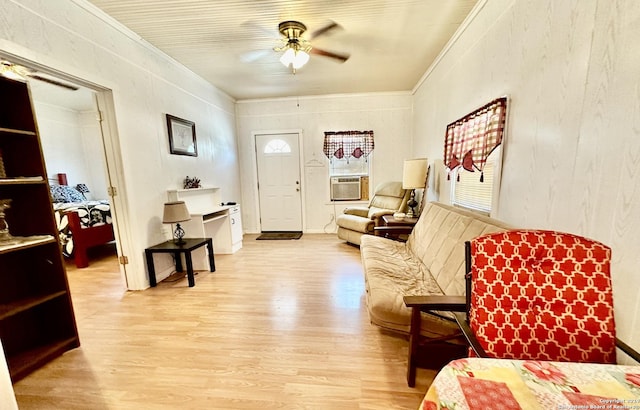 interior space featuring cooling unit, light wood-type flooring, ceiling fan, and crown molding