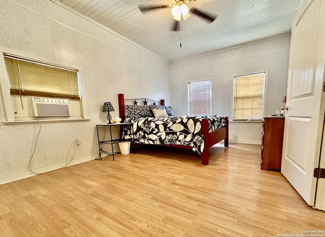 bedroom with cooling unit, ceiling fan, and light hardwood / wood-style flooring