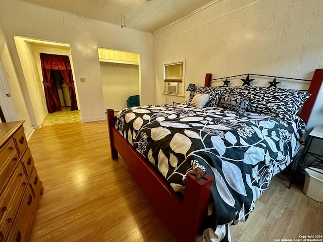 bedroom featuring cooling unit, a closet, and light hardwood / wood-style flooring