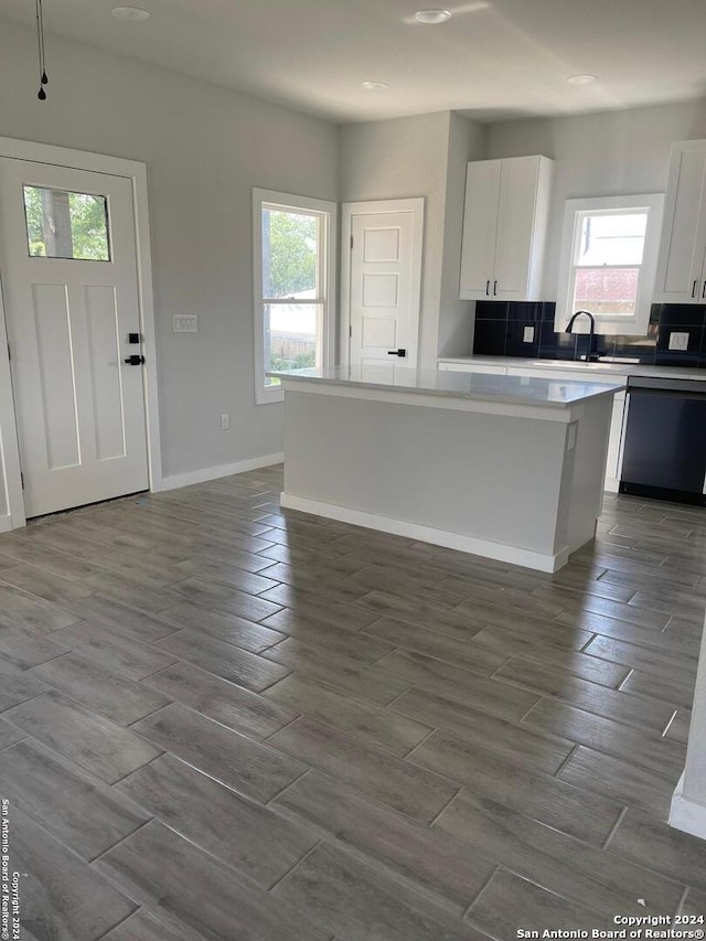 kitchen with plenty of natural light, a kitchen island, and white cabinetry