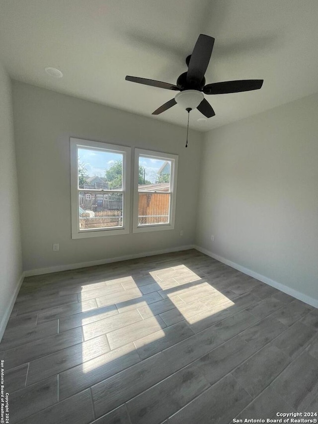 empty room with ceiling fan and hardwood / wood-style flooring