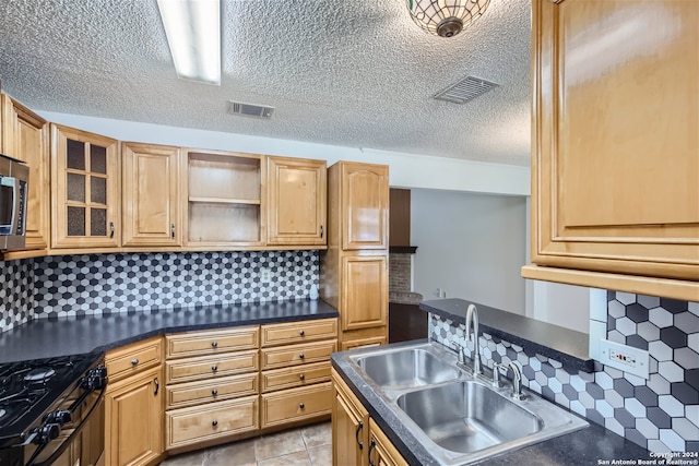 kitchen with a textured ceiling, backsplash, stainless steel appliances, and sink