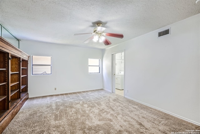 unfurnished room featuring washer / clothes dryer, carpet floors, and a textured ceiling